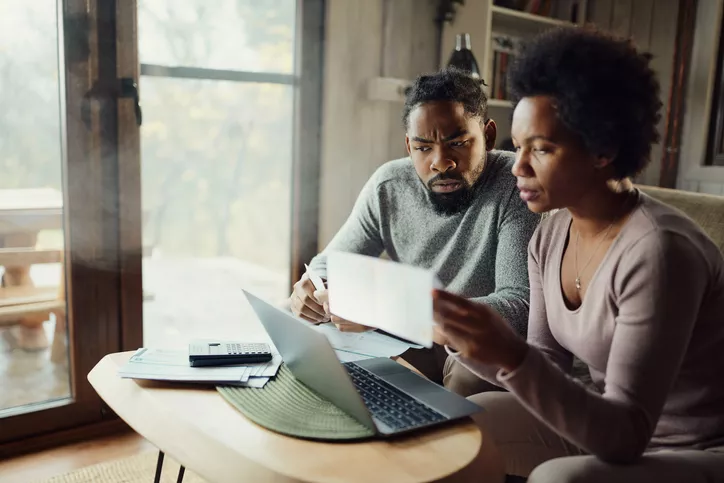 Couple discussing finances in front of their laptop