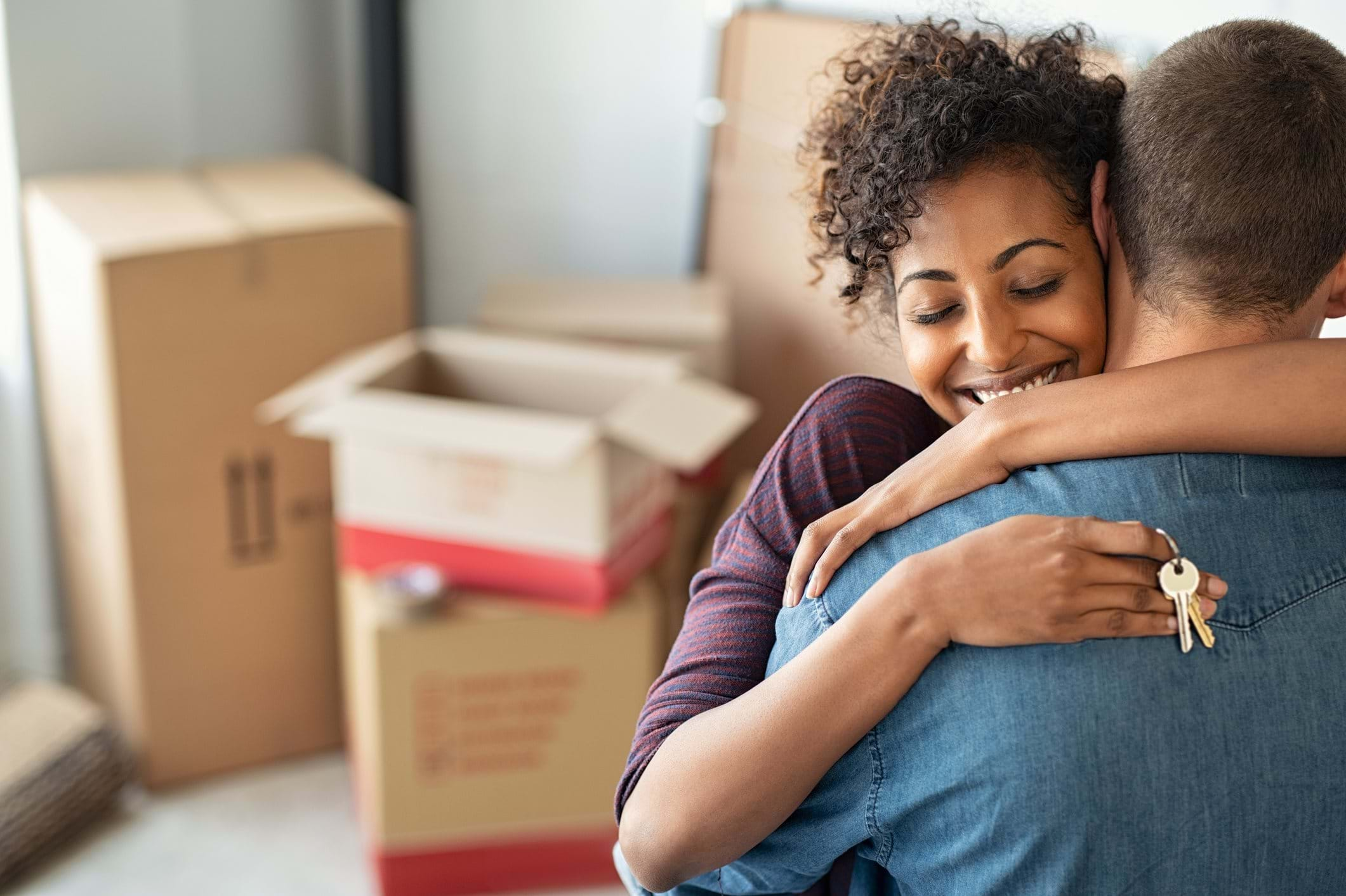 Couple hugging holding the keys to their new home