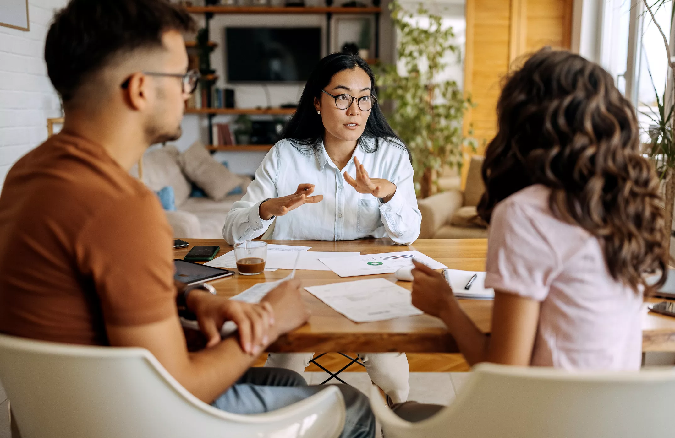 couple is sat down at a table, talking to a financial advisor